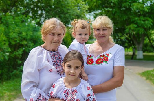 Family photo of a Ukrainian woman in embroidered shirts. Selective focus. Nature.