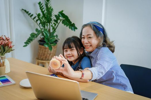 Asian portrait, grandchild granddaughter grandma grandmother and granddaughter happily join in activities to enjoy eating and enhance skills for grandchildren.