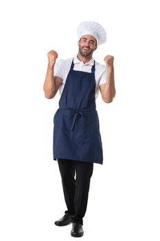 Portrait of happy young cook in uniform standing isolated over white background. Looking camera holding fists.