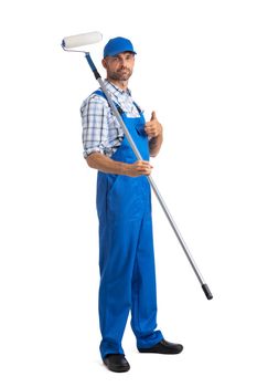 Male house painter in blue coveralls with paint roller tool isolated on white background