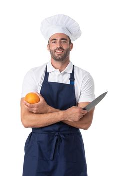 Portrait of a handsome male chef cook holding knife and orange isolated on a white background