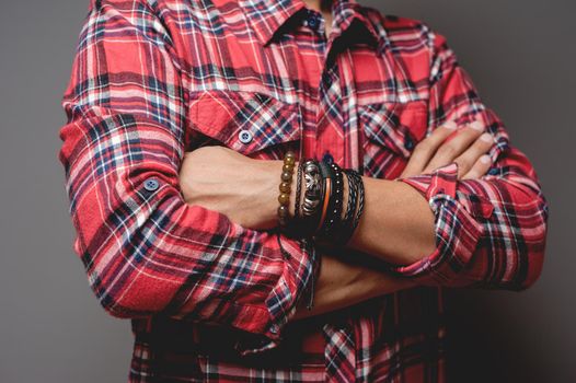 The man in red shirt wearing bracelets, casual style of men accessories. Shallow depth of field.