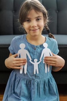 Child with a paper family in his hands. Selective focus. People.