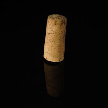 A close-up shot of a wine cork on a reflecting surface.