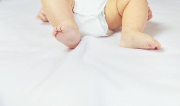 Legs of a little baby on a white background. Selective focus. people.