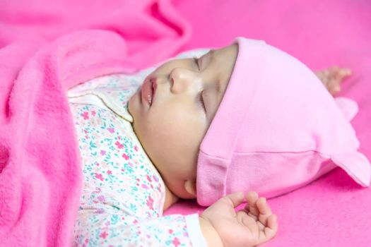 Baby sleeps on a pink bed. Selective focus. people.
