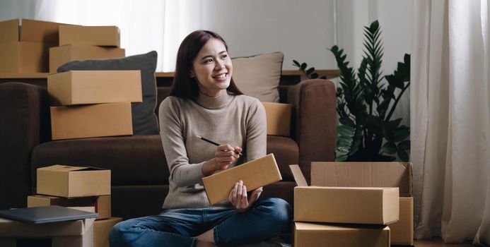 Starting small businesses SME owners female entrepreneurs Write the address on receipt box and check online orders to prepare to pack the boxes, sell to customers, sme business ideas online..