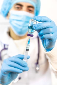 Doctor filling syringe with medication, closeup. Vaccination and immunization. Selective focus. Vaccine.