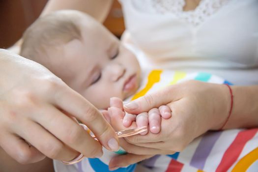 mother cuts little baby's nails. Selective focus. Child.