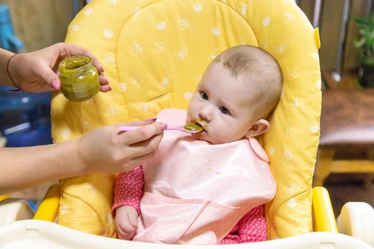 Mom feeds baby with vegetable puree. Selective focus. Food.