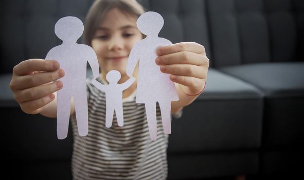 Child with a paper family in his hands. Selective focus. People.