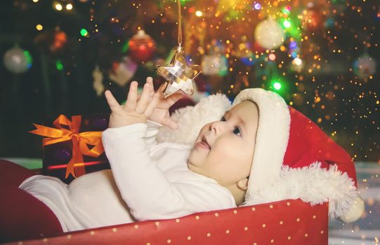 Baby is under the tree, Christmas. Selective focus. Holiday.