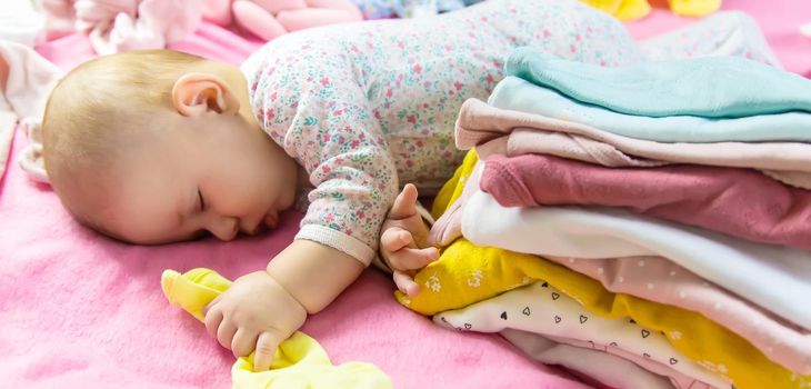 Baby scattered clothes and toys. Selective focus. people.
