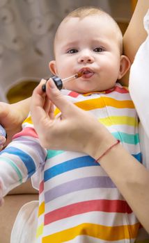 mother gives colic medicine to little baby. Selective focus. child.