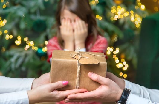 Child girl parents give presents for christmas. Selective focus. Holiday.