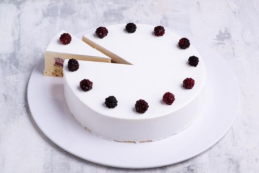 A closeup shot of white-layered cake topped with fresh berries