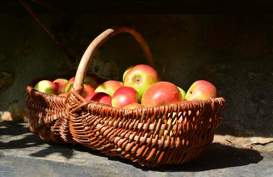 Organic fresh apples in a basket with sinlight