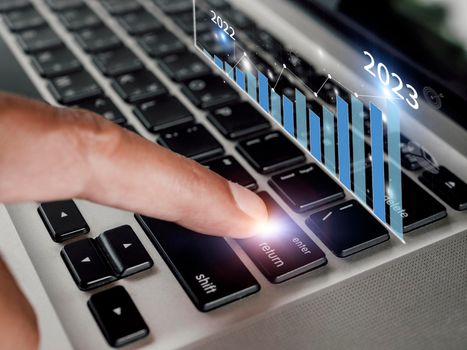 Close up hand Businessman touch enter on laptop keyboard show graph stock market bar chart grow up to target. Business finance concept Businessman analysis and success graph stocks grow 2023 set goals