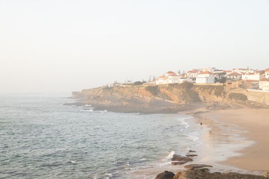 Praia das Macas Apple Beach in Colares, Portugal, on a stormy day before sunset Small city on ocean shore