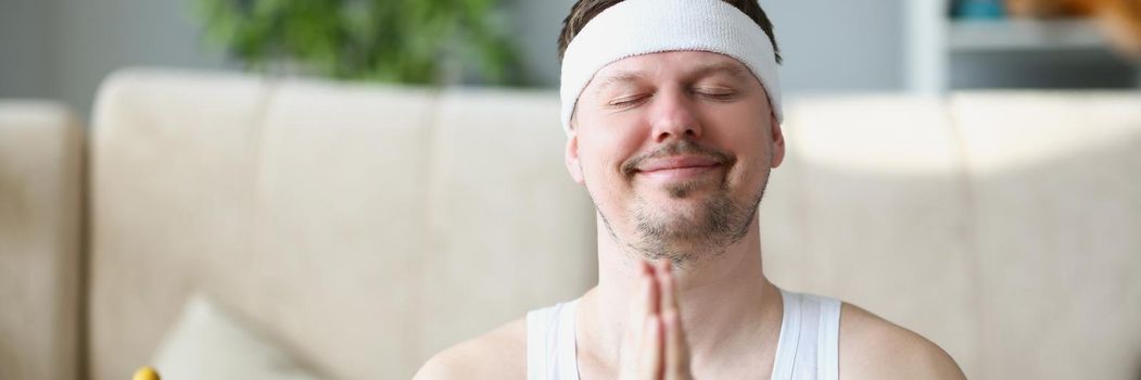 Portrait of middle aged man meditating at home put hands in namaste gesture. Relaxed person start day right creating peace for mind and body. Habit concept