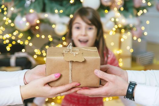 Child girl parents give presents for christmas. Selective focus. Holiday.