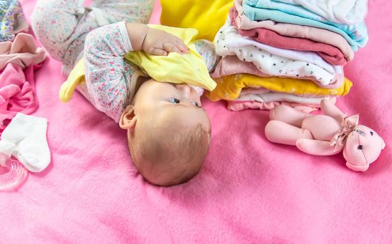 Baby scattered clothes and toys. Selective focus. people.
