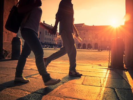 Couple walking in the city hand in hand at sunset. High quality photo