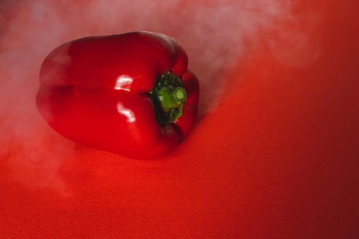 SWEET, fresh RED PEPPER ON RED BACKGROUND With smoke around, pepper. photo for the menu, proper nutrition. fresh vegetables.