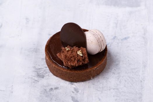 A closeup shot of a delicious chocolate dessert with macaroon