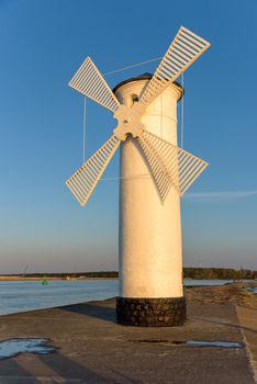 Stawa Mlyny, a beacon in the shape of a windmill as an official symbol of Swinoujscie at sunset