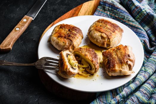 Bacon-wrapped button mushrooms stuffed with grated cheddar cheese and spices