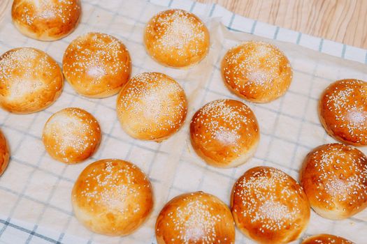 Freshly baked burger buns with sesame seeds. We cook at home.