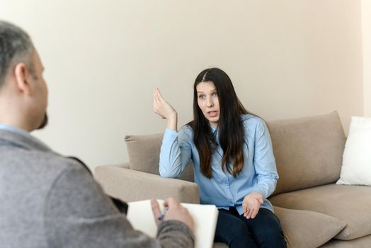 A young woman talks about her problems to a man psychologist. The concept of mental disorders
