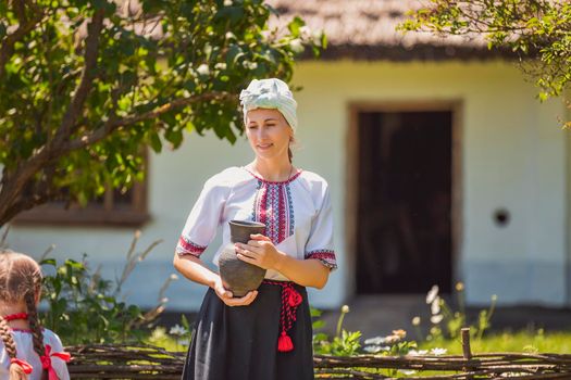 mother and daughter in Ukrainian national costumes near the fence