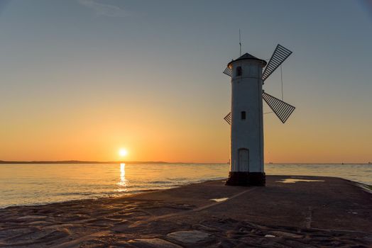 Stawa Mlyny, a beacon in the shape of a windmill as an official symbol of Swinoujscie at sunset