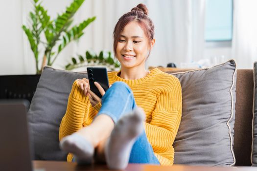 Portrait of Asian woman chatting with friend online in mobile chat app using smartphone video chat application