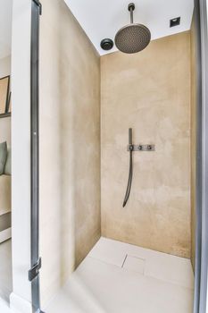 Spacious beige bathroom with shower cabinContemporary bathroom with bathtub and glass shower cabin with light beige tile and white ceiling