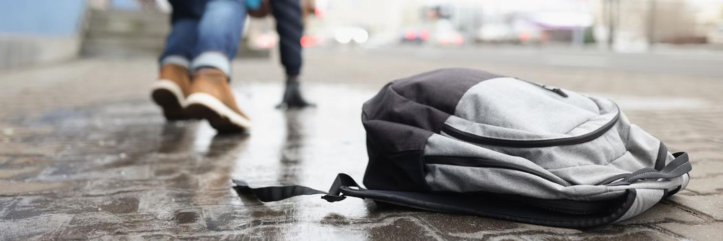 Close-up of man almost fell on ground because of slippery weather. Backpack with personal things on asphalt. Winter, weather conditions, trauma concept