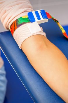 Medical tourniquet on the hand of female patient in the hospital