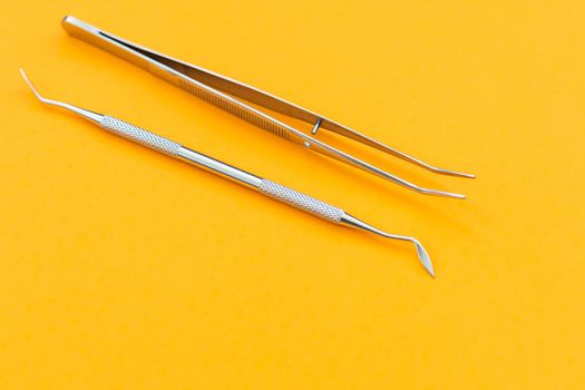 dental tool on an orange background.