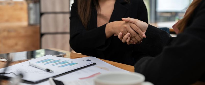 Businesswomen handshaking join to form a startup, Handshaking is a Western greeting or congratulation. two businesswomen form startups and are growing higher. Startup idea.