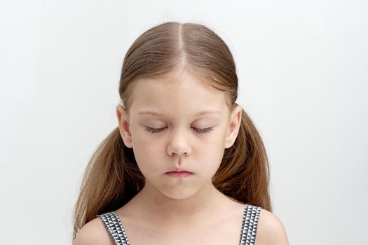 Portrait of caucasian calm little girl of 6 years with closed eyes on white background