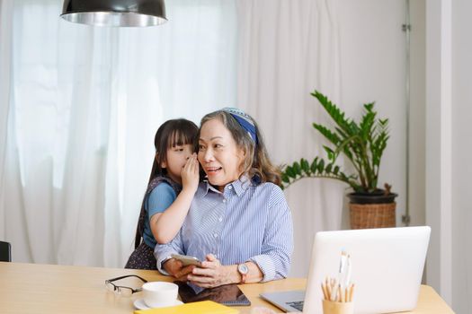 Asian portrait, grandmother and granddaughter doing leisure with little children whispering secrets between each other.