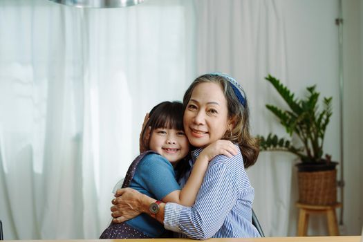 Asian portrait, grandma and granddaughter doing leisure activities and hugging to show their love and care for each other.