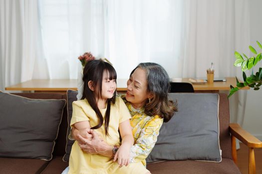 Asian portrait, grandma and granddaughter doing leisure activities and hugging to show their love and care for each other.