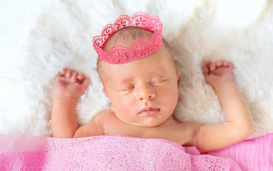 Newborn baby in a girl crown. Selective focus. people.