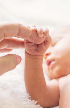 newborn baby is holding mother's hand. selective focus. people.