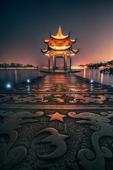 illuminated ancient Jixian Pavilion at West Lake, Hangzhou, China. All Chinese words only introduce itself which means Jixian Pavilion without advertisement.