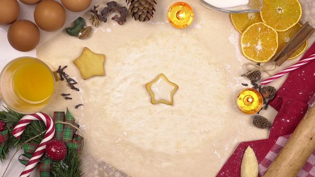 A young woman decorates festive Christmas cookies with colored star icing. View from above. 4k