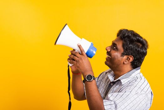 Asian happy portrait young black woman standing to make announcement message shouting screaming in megaphone, studio shot isolated on yellow background with copy space